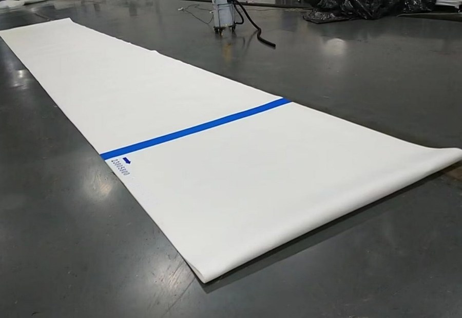 Press felt material laid flat for paper machine dewatering position selection